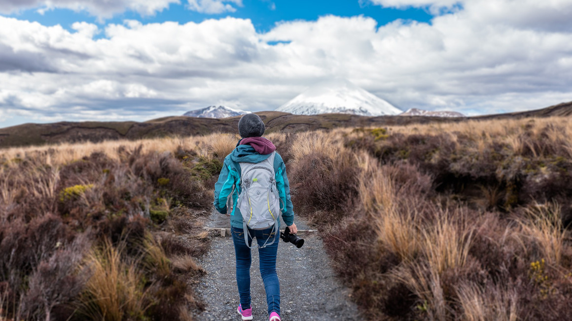 Frau mit Outdoor-Kleidung und Rucksack beim Wandern in den Bergen