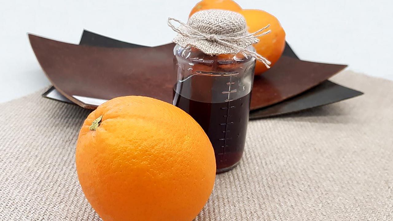 Orange, Glas mit brauner Flüssigkeit und Proben von Bioverbundwerkstoffen
