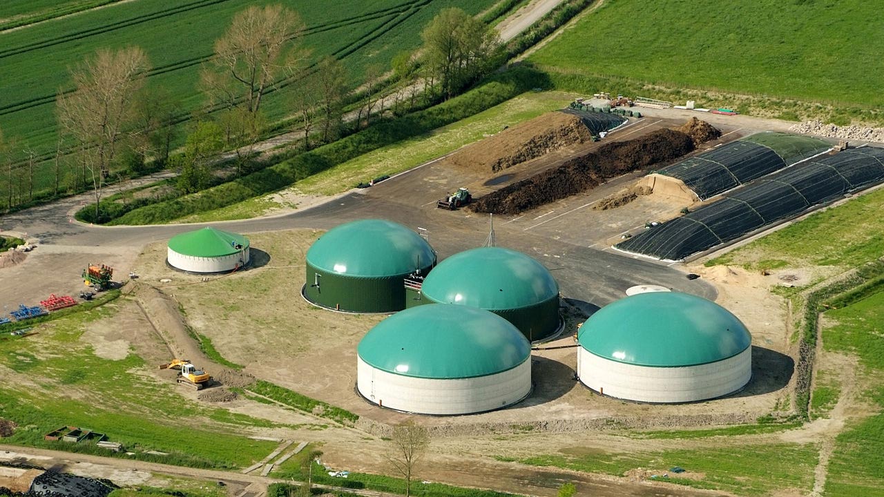 Luftbild eines Biogasanlage mit runden Gebäudestrukturen mit türkisen Dächern