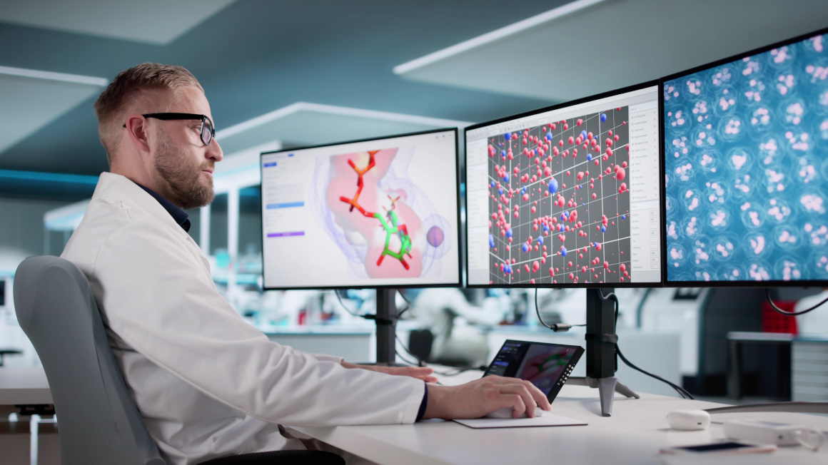 Mann analysiert Proteinstrukturen auf mehreren Computerbildschirmen