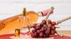 Eine Flasche Wein, ein Parfümflakon und eine Traube Weinbeeren