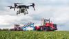 Moderne Technologien in der Landwirtschaft. Industrielle Drohnen fliegen über grüne Felder, sprühen Pestizide, um die Produktivität zu steigern, und vernichten schädliche Insekten.