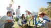 group of volunteers planting tree in park