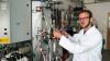 Fabian Bonk vor dem Bioreaktor im Labor